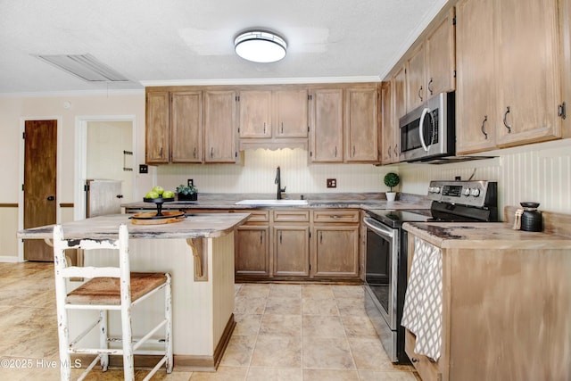 287 Perkins Rd, Goldsboro, NC 27530 - kitchen featuring appliances with stainless steel finishes, a sink, crown molding, a kitchen breakfast bar, and a kitchen island