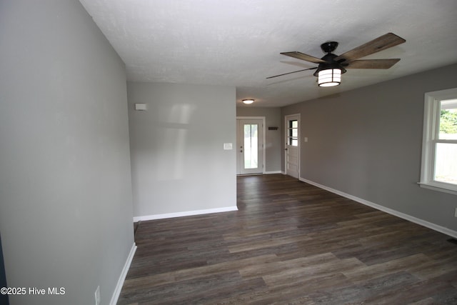 114 Pinecone Ln, Havelock, NC 28532 - empty room with baseboards, healthy amount of natural light, dark wood-type flooring, a ceiling fan, and a textured ceiling