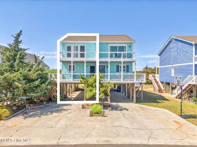256 Brunswick Ave W Unit A, Holden Beach, NC 28462 - rear view of house featuring a carport, driveway, stairway, and a balcony