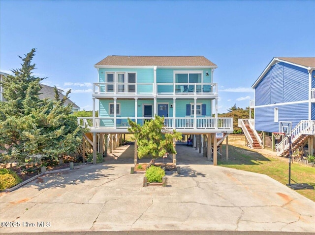 256 Brunswick Ave W Unit A, Holden Beach, NC 28462 - view of front of house with a carport, driveway, a balcony, and stairs
