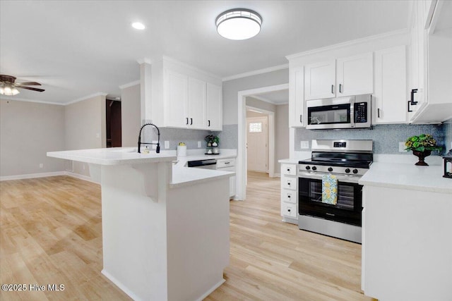 103 Sawgrass Pl, Goldsboro, NC 27534 - kitchen featuring stainless steel appliances, a peninsula, ceiling fan, backsplash, and crown molding