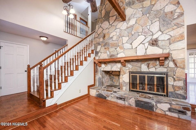 549 Lucas Rd, West End, NC 27376 - unfurnished living room featuring stairs, baseboards, a stone fireplace, and wood finished floors