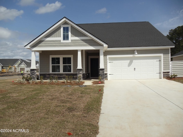 8715 NW Baton Rouge Ave NW Unit 1155-, St Phillips, Calabash, NC 28467 - craftsman house with concrete driveway, a porch, an attached garage, a front yard, and stone siding