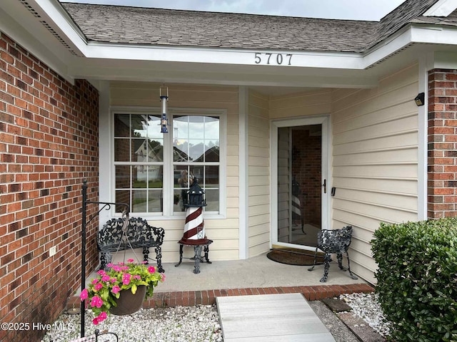 5707 Mossberg Ct, Wilmington, NC 28405 - entrance to property featuring covered porch, roof with shingles, and brick siding
