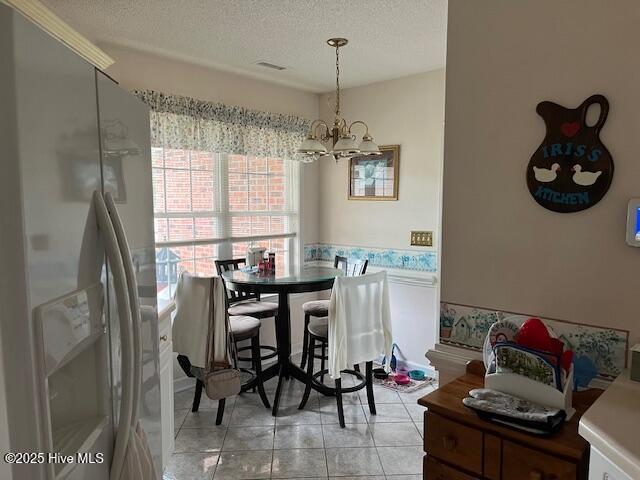 5707 Mossberg Ct, Wilmington, NC 28405 - dining area with a textured ceiling, a chandelier, and light tile patterned floors