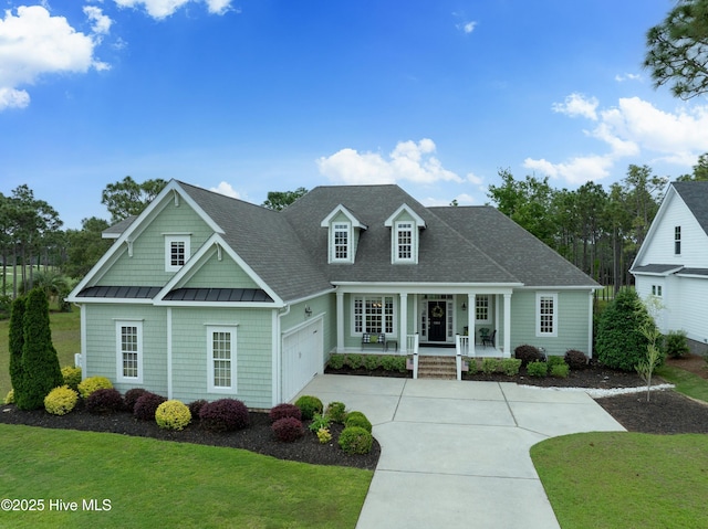 3059 Irwin Dr SE, Southport, NC 28461 - view of front facade featuring a porch, a standing seam roof, driveway, and a front lawn