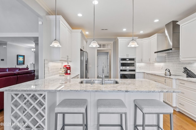 3059 Irwin Dr SE, Southport, NC 28461 - kitchen featuring wall chimney range hood, a sink, appliances with stainless steel finishes, a peninsula, and ornamental molding