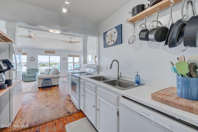 1904 Ocean Blvd, Topsail Beach, NC 28445 - kitchen featuring white appliances, a sink, ceiling fan, light wood finished floors, and white cabinetry