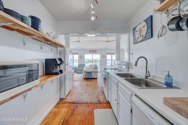 1904 Ocean Blvd, Topsail Beach, NC 28445 - kitchen featuring white appliances, open shelves, light wood-style floors, a sink, and white cabinetry