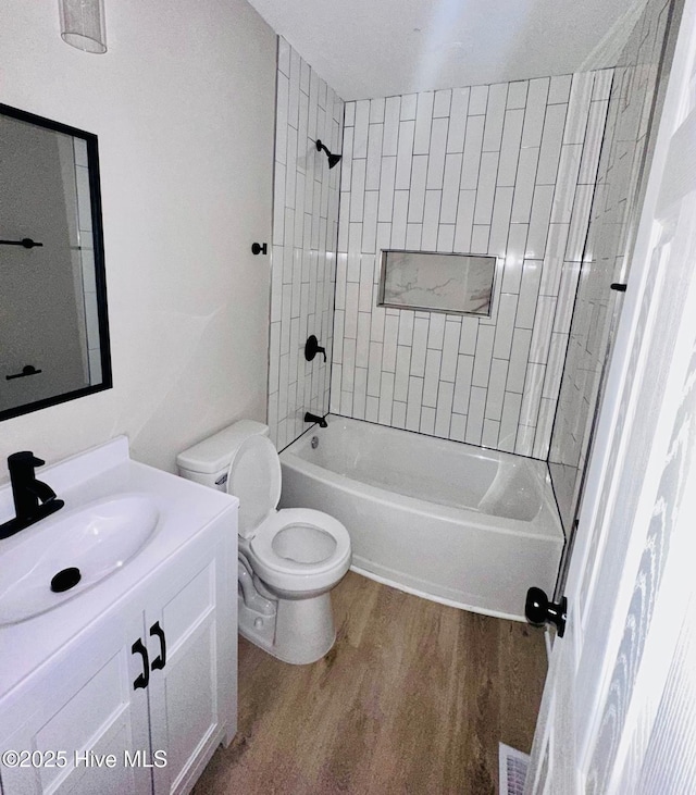 1200 N Center St, Goldsboro, NC 27530 - bathroom with toilet, wood finished floors, vanity, and bathing tub / shower combination