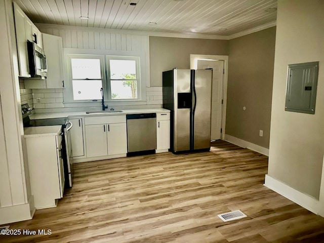 1200 N Center St, Goldsboro, NC 27530 - kitchen featuring stainless steel appliances, electric panel, a sink, ornamental molding, and white cabinetry