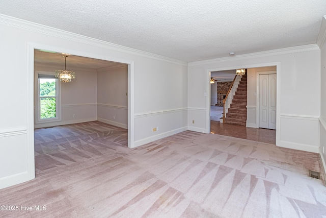 102 Plantation Rd, Goldsboro, NC 27530 - carpeted spare room with stairway, a chandelier, a textured ceiling, crown molding, and baseboards
