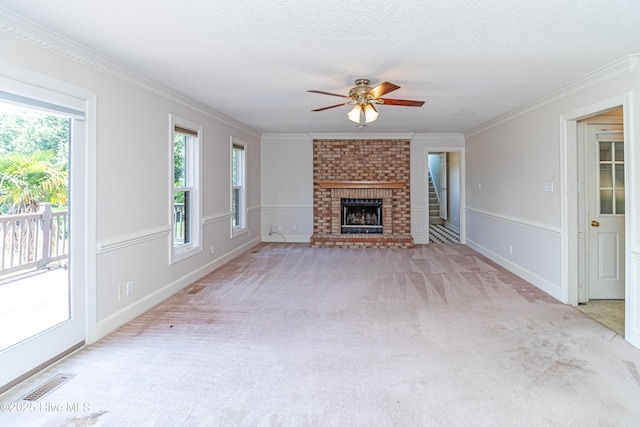 102 Plantation Rd, Goldsboro, NC 27530 - unfurnished living room featuring a ceiling fan, crown molding, light colored carpet, a brick fireplace, and a textured ceiling