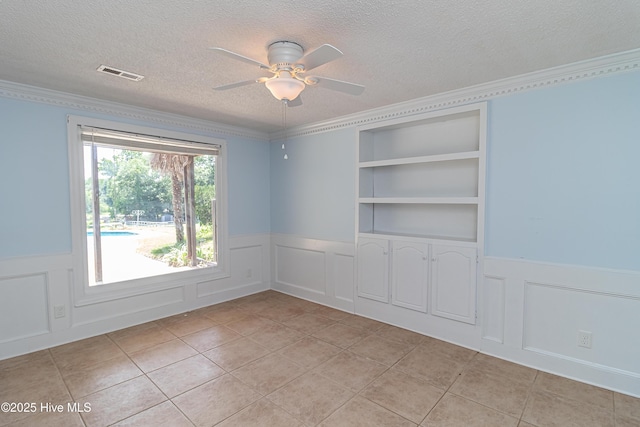 102 Plantation Rd, Goldsboro, NC 27530 - unfurnished room with wainscoting, a textured ceiling, a decorative wall, a ceiling fan, and light tile patterned flooring