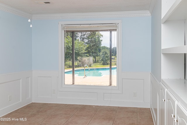 102 Plantation Rd, Goldsboro, NC 27530 - spare room with wainscoting, a decorative wall, light tile patterned floors, crown molding, and a textured ceiling