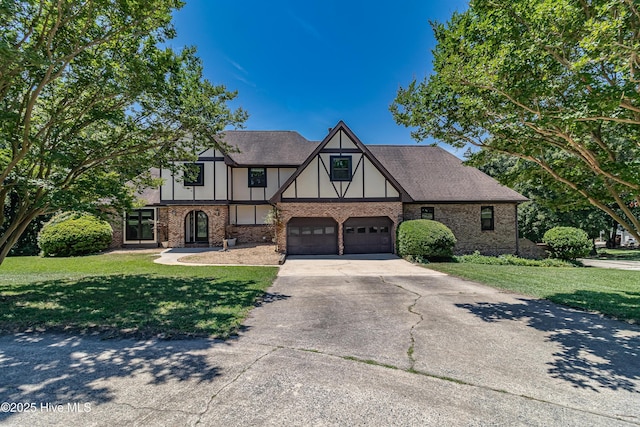 102 Plantation Rd, Goldsboro, NC 27530 - english style home featuring driveway, brick siding, a front yard, and a garage