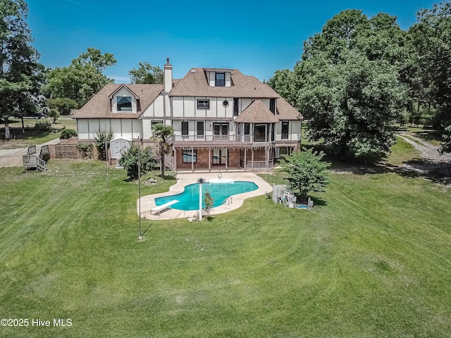 102 Plantation Rd, Goldsboro, NC 27530 - rear view of house featuring a balcony, a chimney, a lawn, a patio area, and an outdoor pool