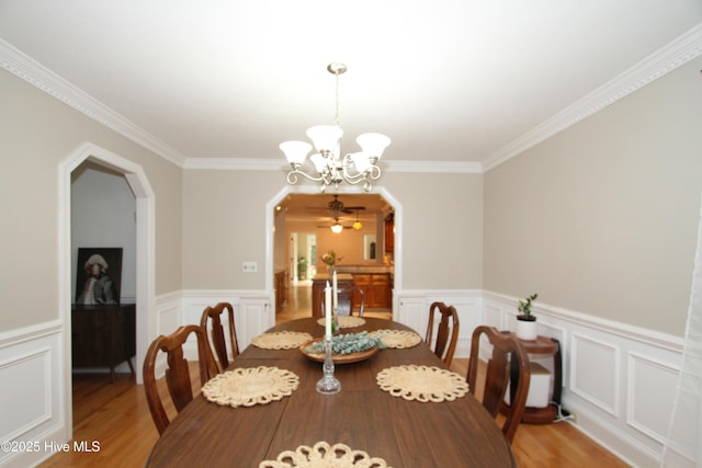 1317 Worthington Ln, Greenville, NC 27858 - dining room with a chandelier, light wood-style floors, ornamental molding, arched walkways, and wainscoting