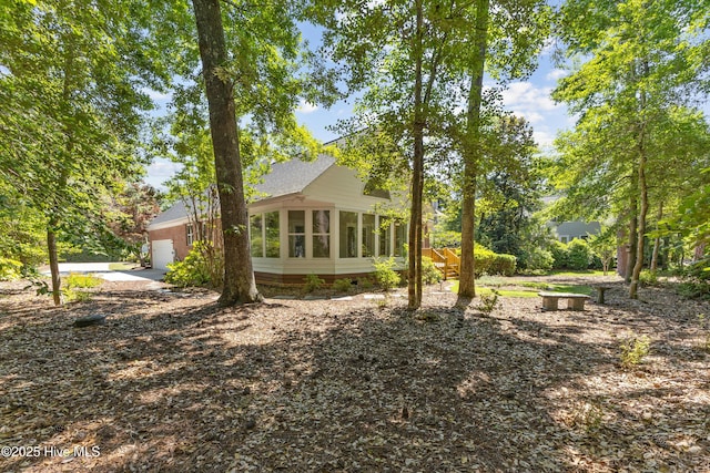 8807 Sawmill Creek Ln, Wilmington, NC 28411 - view of side of property with a sunroom, an attached garage, crawl space, and roof with shingles