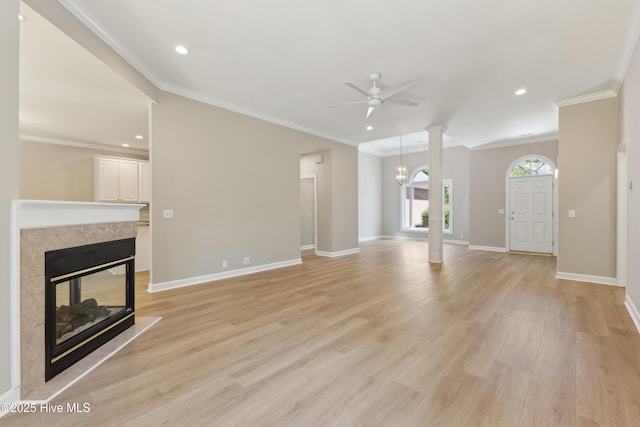 8807 Sawmill Creek Ln, Wilmington, NC 28411 - unfurnished living room featuring a tiled fireplace, ceiling fan, light wood-type flooring, baseboards, and ornamental molding