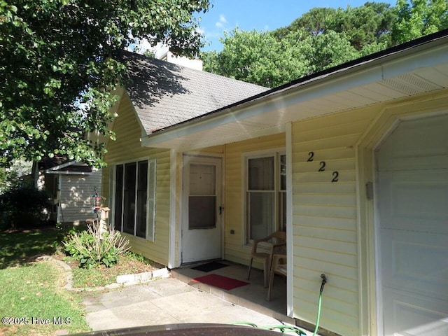 222 Rivershore Dr, New Bern, NC 28560 - property entrance with a shingled roof, a chimney, a patio, and a garage