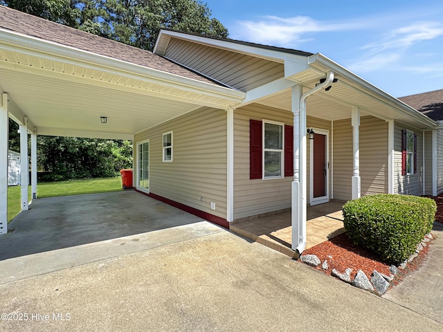 130 Summerfield St, Elizabeth City, NC 27909 - view of home's exterior featuring concrete driveway, a shingled roof, an attached carport, and covered porch