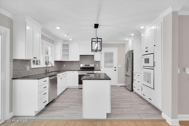 3417 Chalmers Dr, Wilmington, NC 28409 - kitchen featuring appliances with stainless steel finishes, a sink, a center island, baseboards, and ornamental molding
