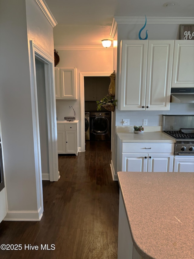 141 N River Rd, Plymouth, NC 27962 - kitchen with washing machine and clothes dryer, white cabinetry, under cabinet range hood, dark wood-style floors, and crown molding