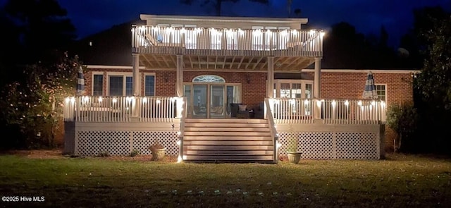 141 N River Rd, Plymouth, NC 27962 - back of house at night with stairs, brick siding, a deck, and a yard