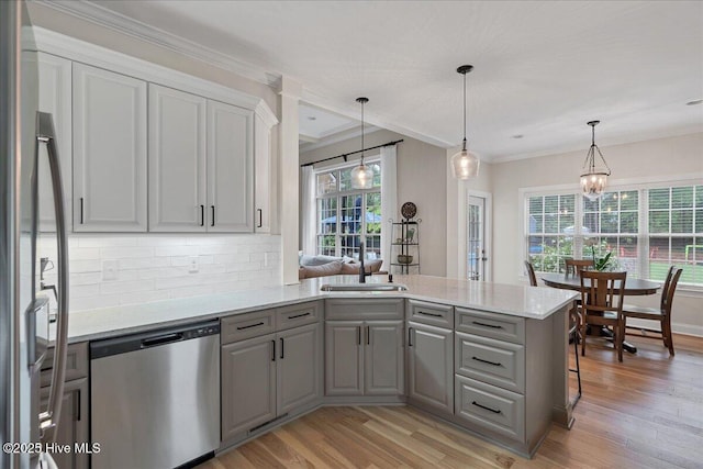 42 Spearhead Dr, Whispering Pines, NC 28327 - kitchen featuring stainless steel appliances, gray cabinets, a peninsula, light wood finished floors, and crown molding