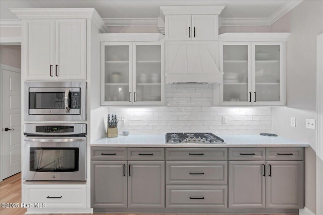 42 Spearhead Dr, Whispering Pines, NC 28327 - kitchen featuring stainless steel appliances, gray cabinetry, decorative backsplash, crown molding, and white cabinets