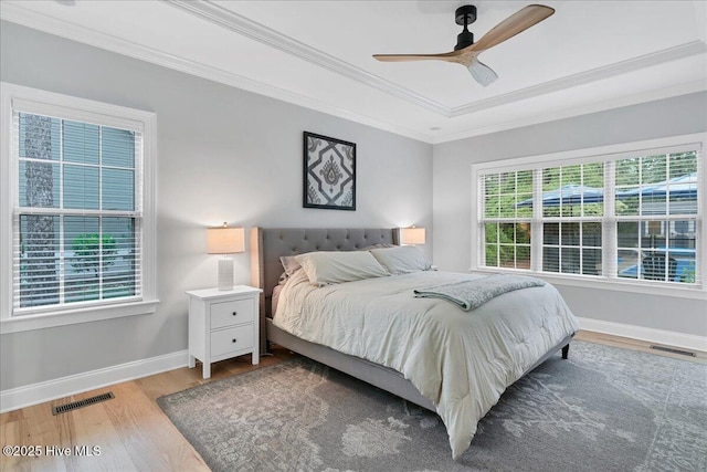 42 Spearhead Dr, Whispering Pines, NC 28327 - bedroom featuring wood finished floors, baseboards, ornamental molding, a raised ceiling, and a ceiling fan