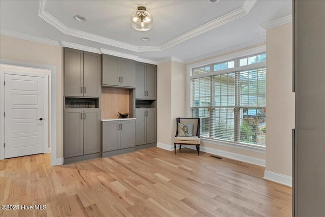 42 Spearhead Dr, Whispering Pines, NC 28327 - kitchen with gray cabinets, light wood finished floors, healthy amount of natural light, baseboards, and ornamental molding