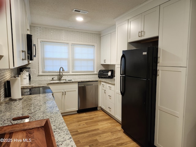 1108 Plymouth Dr, New Bern, NC 28562 - kitchen featuring appliances with stainless steel finishes, a sink, a textured ceiling, tasteful backsplash, and white cabinetry