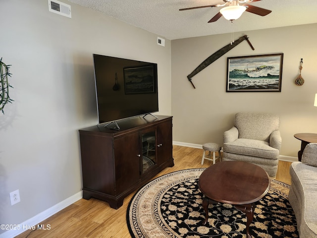 1108 Plymouth Dr, New Bern, NC 28562 - living area featuring light wood-style flooring, ceiling fan, a textured ceiling, and baseboards