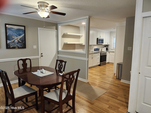 1108 Plymouth Dr, New Bern, NC 28562 - dining room featuring light wood-style flooring, a ceiling fan, a textured ceiling, and baseboards