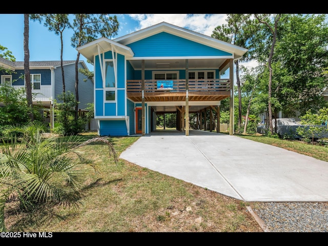 119 NE 27th St, Oak Island, NC 28465 - coastal inspired home with a carport, concrete driveway, and a front yard