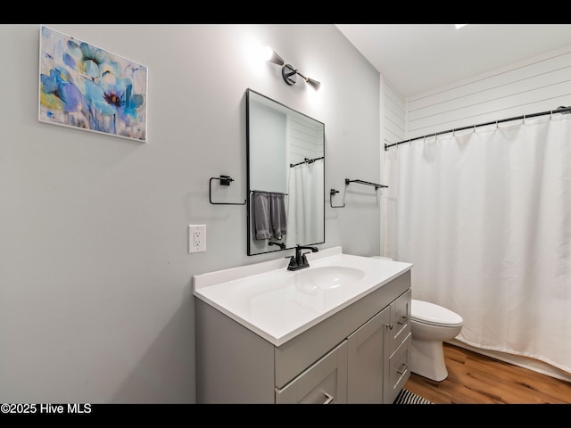 119 NE 27th St, Oak Island, NC 28465 - full bathroom with toilet, vanity, wood finished floors, and curtained shower
