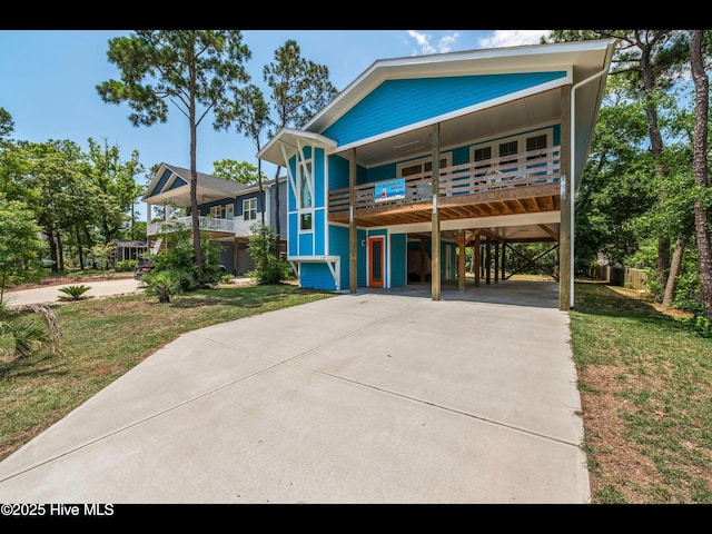 119 NE 27th St, Oak Island, NC 28465 - view of front facade featuring a carport, concrete driveway, and a front yard