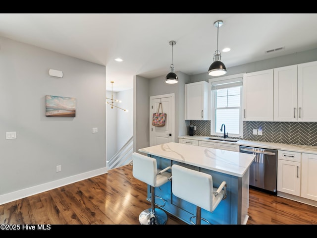 119 NE 27th St, Oak Island, NC 28465 - kitchen with stainless steel dishwasher, a sink, tasteful backsplash, baseboards, and white cabinetry