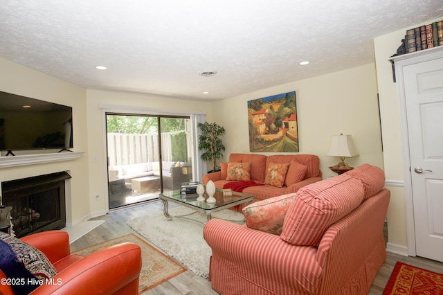 940 Linden Rd Unit 19, Pinehurst, NC 28374 - living room with wood finished floors, a fireplace, recessed lighting, a textured ceiling, and baseboards