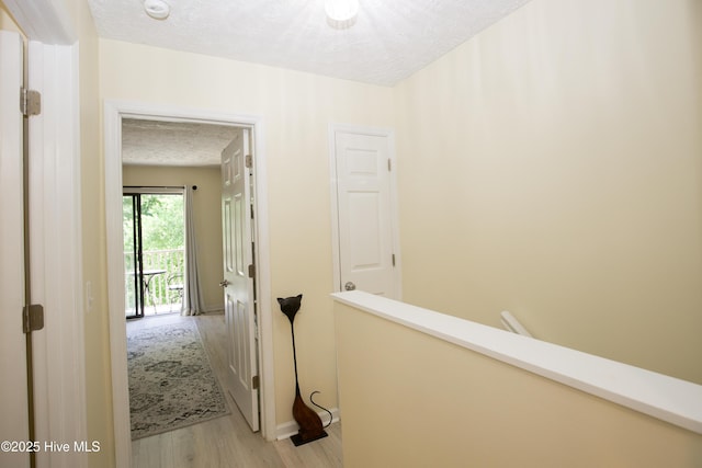 940 Linden Rd Unit 19, Pinehurst, NC 28374 - hallway with light wood-type flooring, a textured ceiling, and an upstairs landing