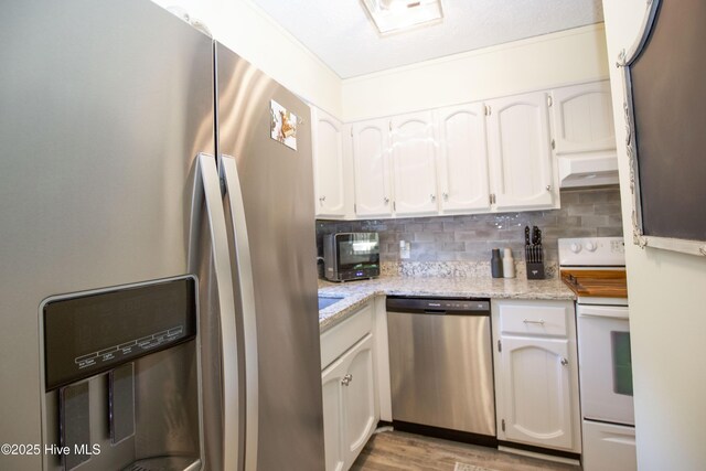 940 Linden Rd Unit 19, Pinehurst, NC 28374 - kitchen featuring appliances with stainless steel finishes, decorative backsplash, white cabinets, light stone counters, and light wood finished floors