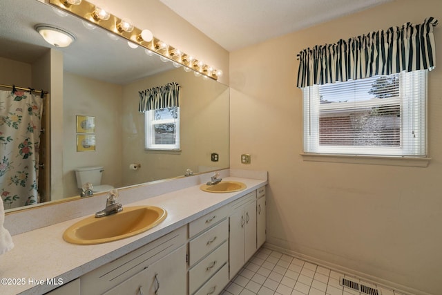 1606 Palm St, Goldsboro, NC 27530 - full bath featuring healthy amount of natural light, tile patterned flooring, double vanity, and toilet