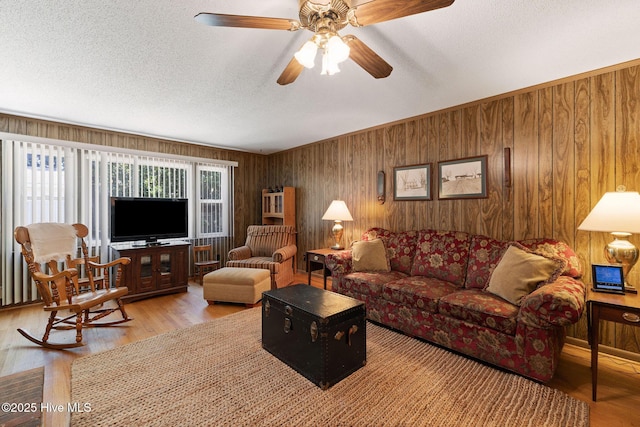 1606 Palm St, Goldsboro, NC 27530 - living room with wooden walls, wood finished floors, a textured ceiling, and a ceiling fan