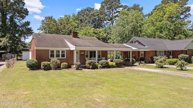 1606 Palm St, Goldsboro, NC 27530 - view of front of home featuring brick siding, a front yard, a chimney, and roof with shingles