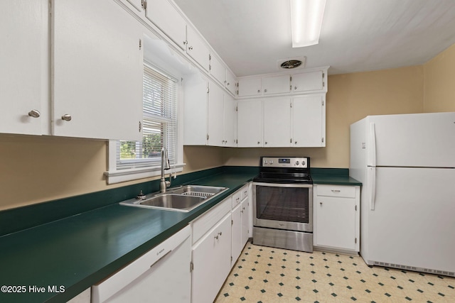 1606 Palm St, Goldsboro, NC 27530 - kitchen featuring white appliances, a sink, dark countertops, white cabinetry, and light floors