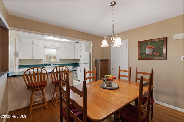 1606 Palm St, Goldsboro, NC 27530 - dining space with dark wood-style floors, baseboards, and a chandelier
