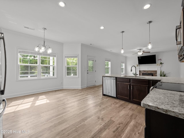 608 Creek Ct, Swansboro, NC 28584 - kitchen with stainless steel dishwasher, a sink, open floor plan, a fireplace, and ornamental molding