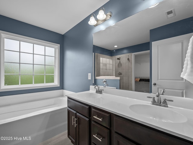 608 Creek Ct, Swansboro, NC 28584 - full bathroom featuring a stall shower, double vanity, a garden tub, and a walk in closet